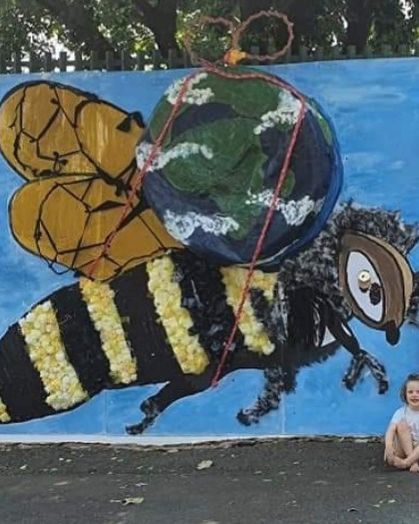 A large painted bee mural on the school wall